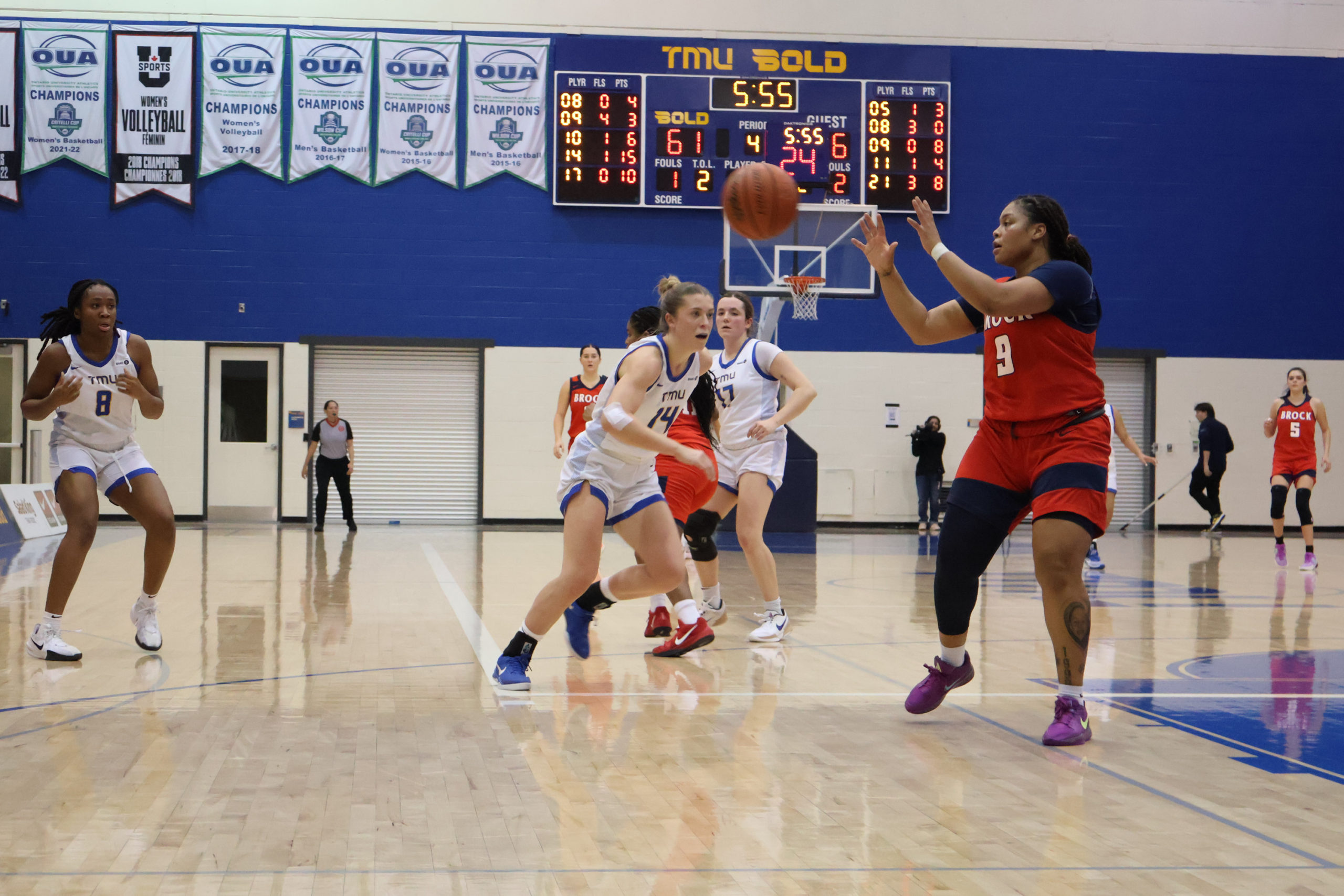 Kaillie Hall runs towards a Brock Badgers player who is about to catch a basketball