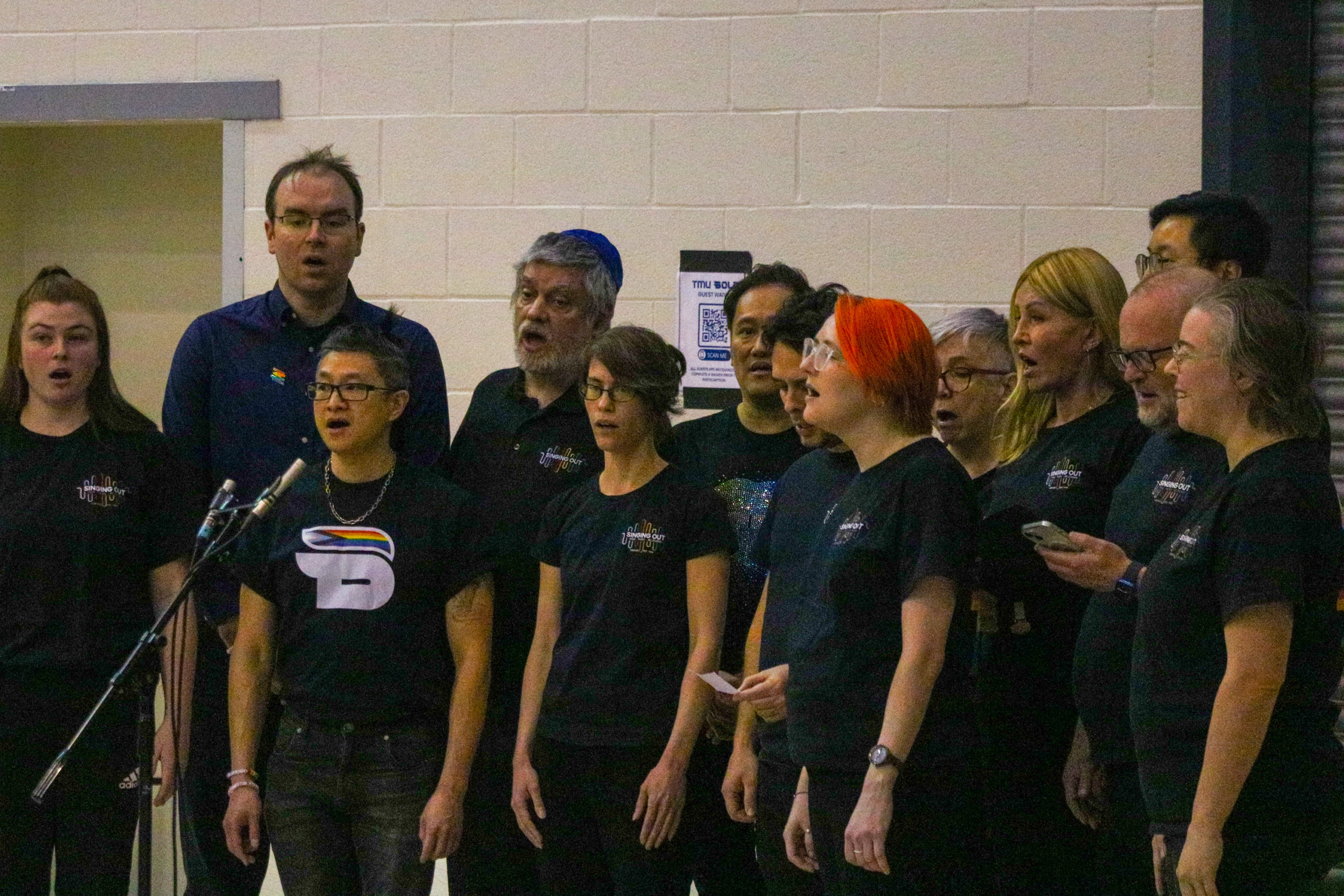 Members of the Singing Out choir sing the national anthem at a TMU Bold game