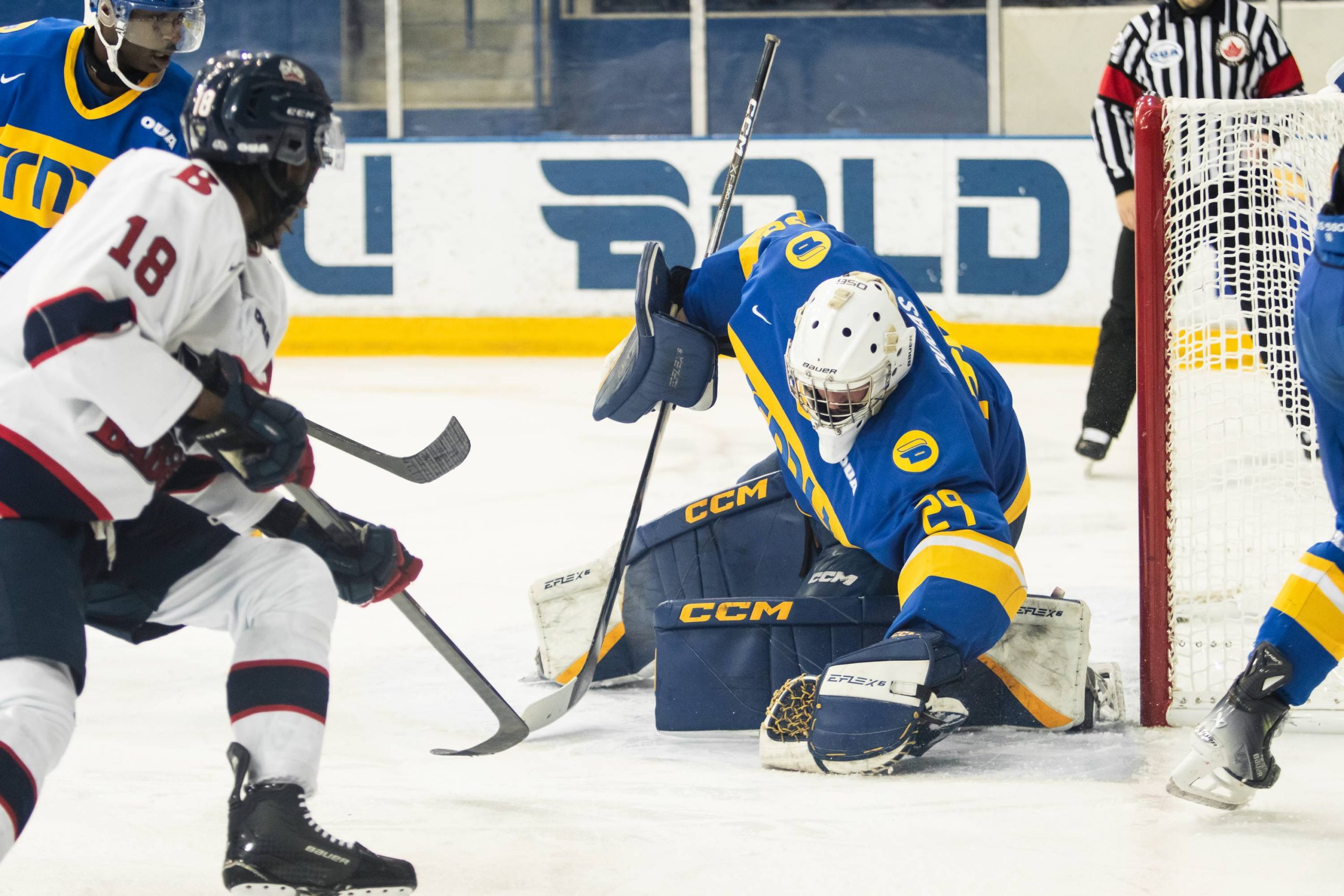 Ryan Dugas covers a puck as Brock Badgers players go to the net