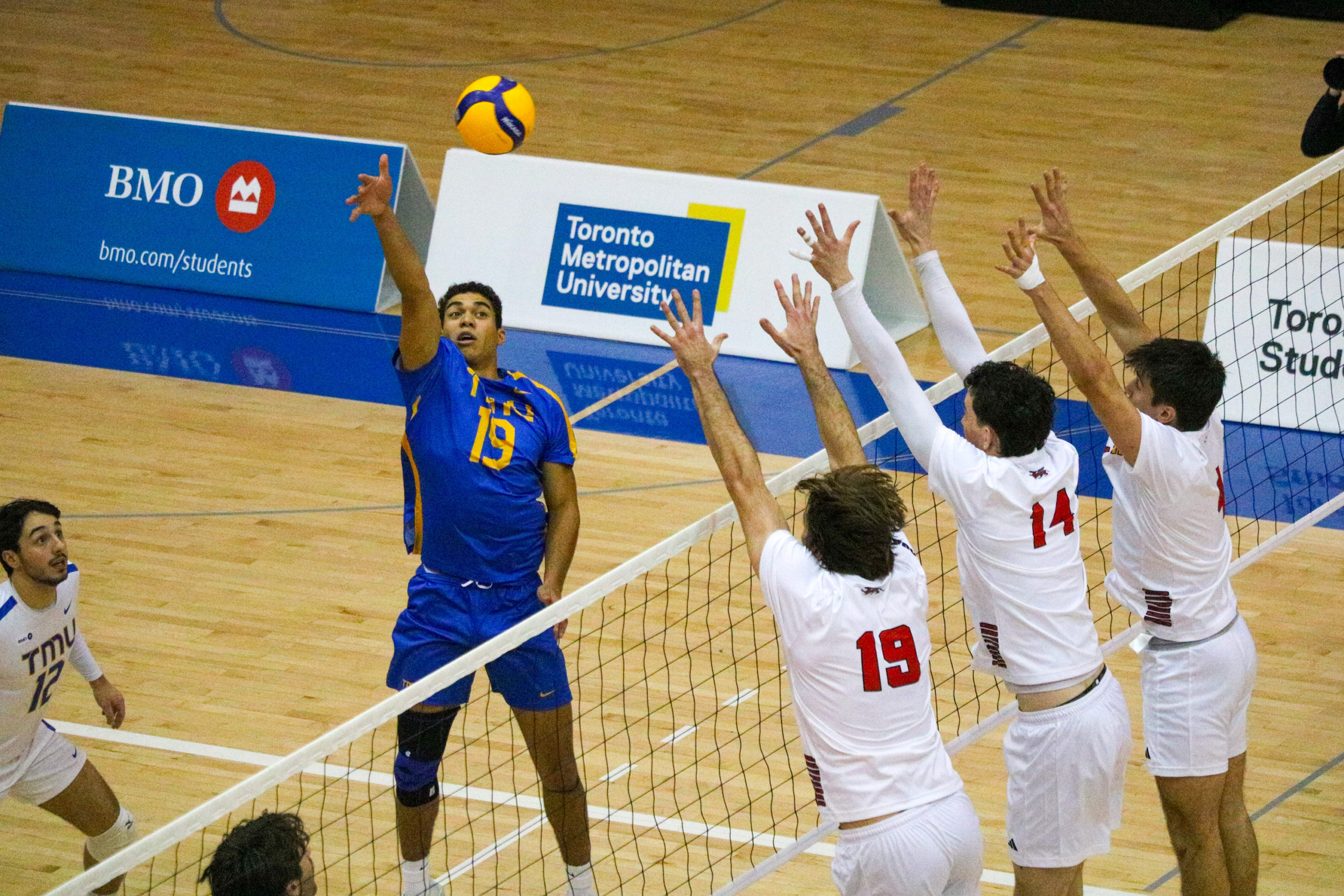 Jacob Walker hitting the ball in a three man block