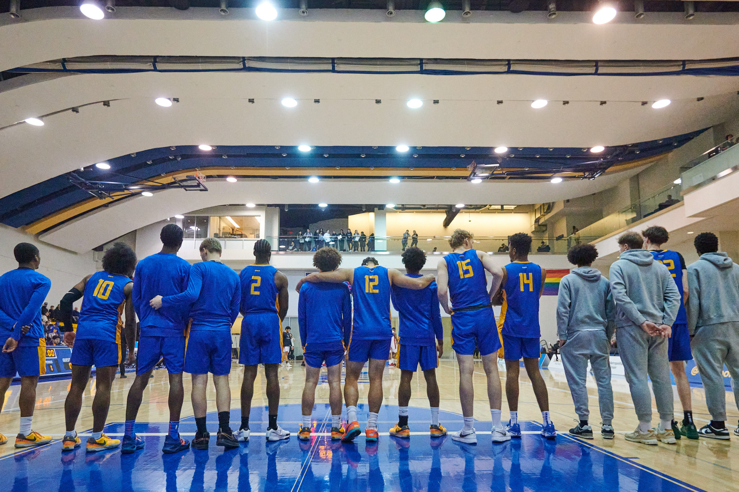 TMU Bold men's basketball players line up for the anthem