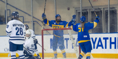 Emily Baxter and Megan Breen raise their arms and sticks to celebrate a goal against the Toronto Varsity Blues