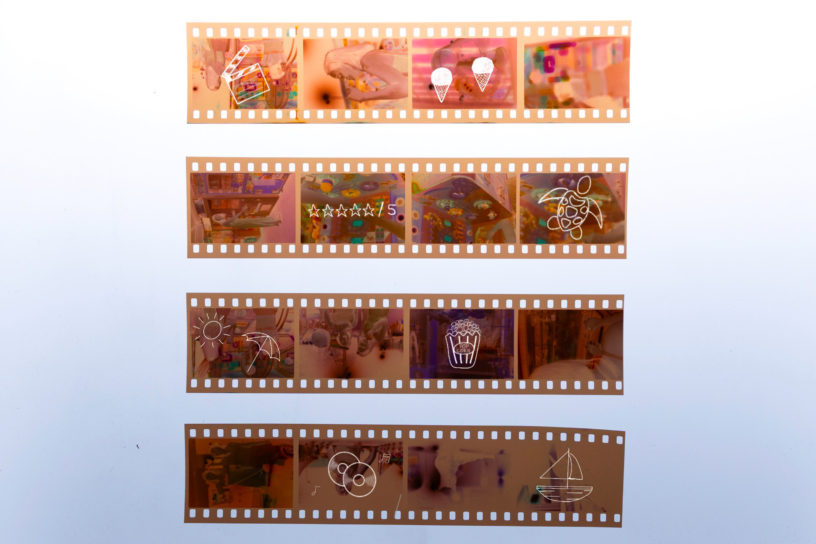 An image of film negatives with small drawings of summer and movie related objects and activities on top.