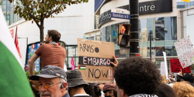 A crowd of protesters from behind holding signs at Sankofa Square.