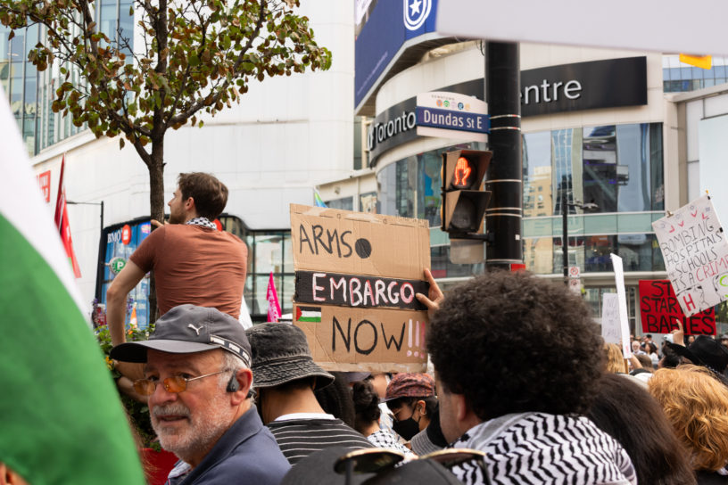 A crowd of protesters from behind holding signs at Sankofa Square.