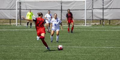 A soccer player prepares to kick a ball towards a net