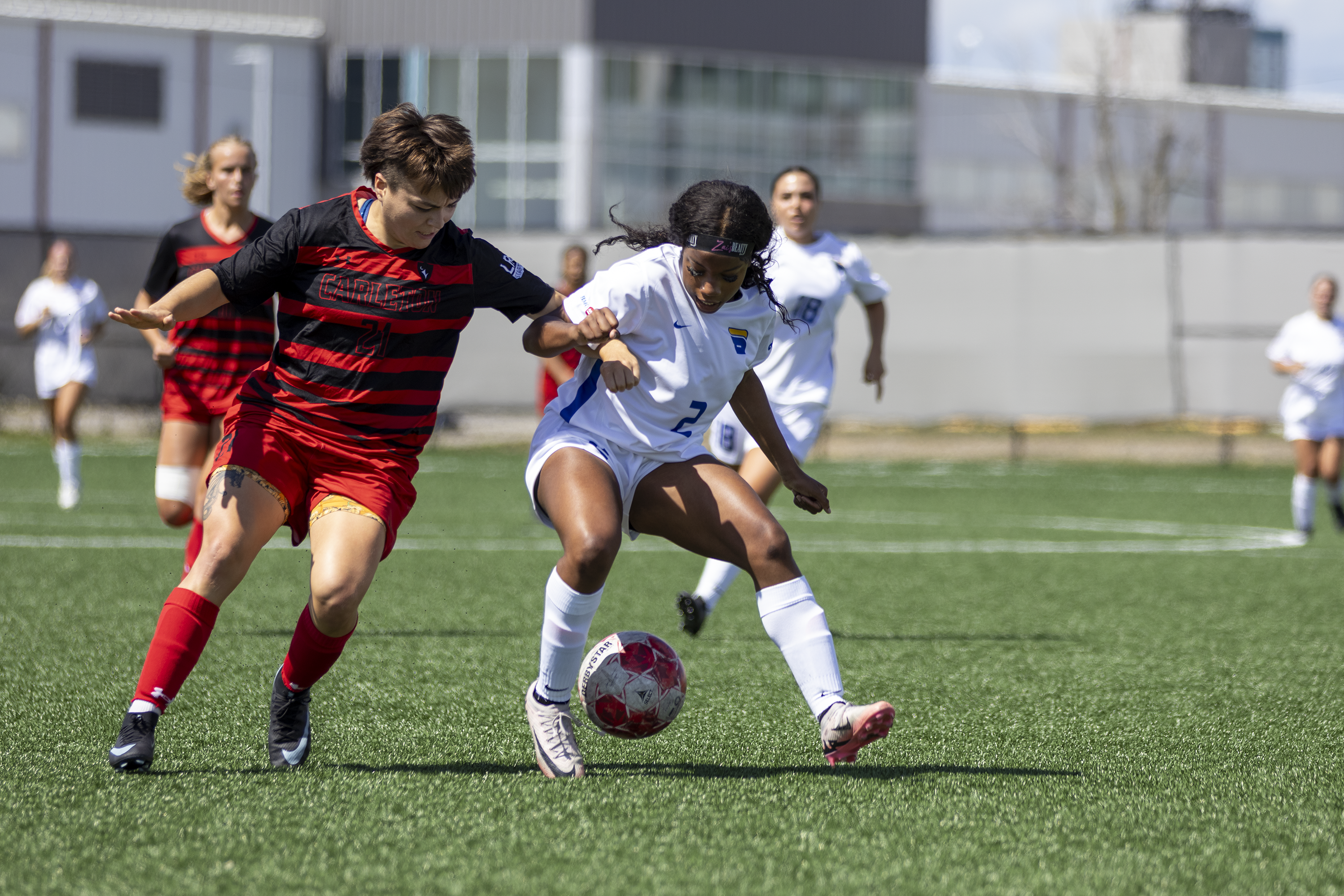 Two soccer players fight for the ball