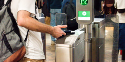 A student taps their phone at the TTC gates.