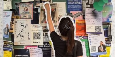 Composition of a student in the middle of a poster board with their arm up.