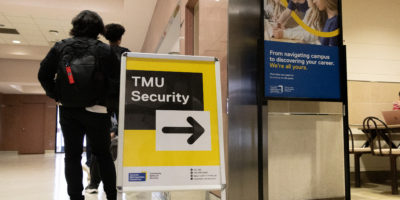 Photo of TMU security sign in a hallway.