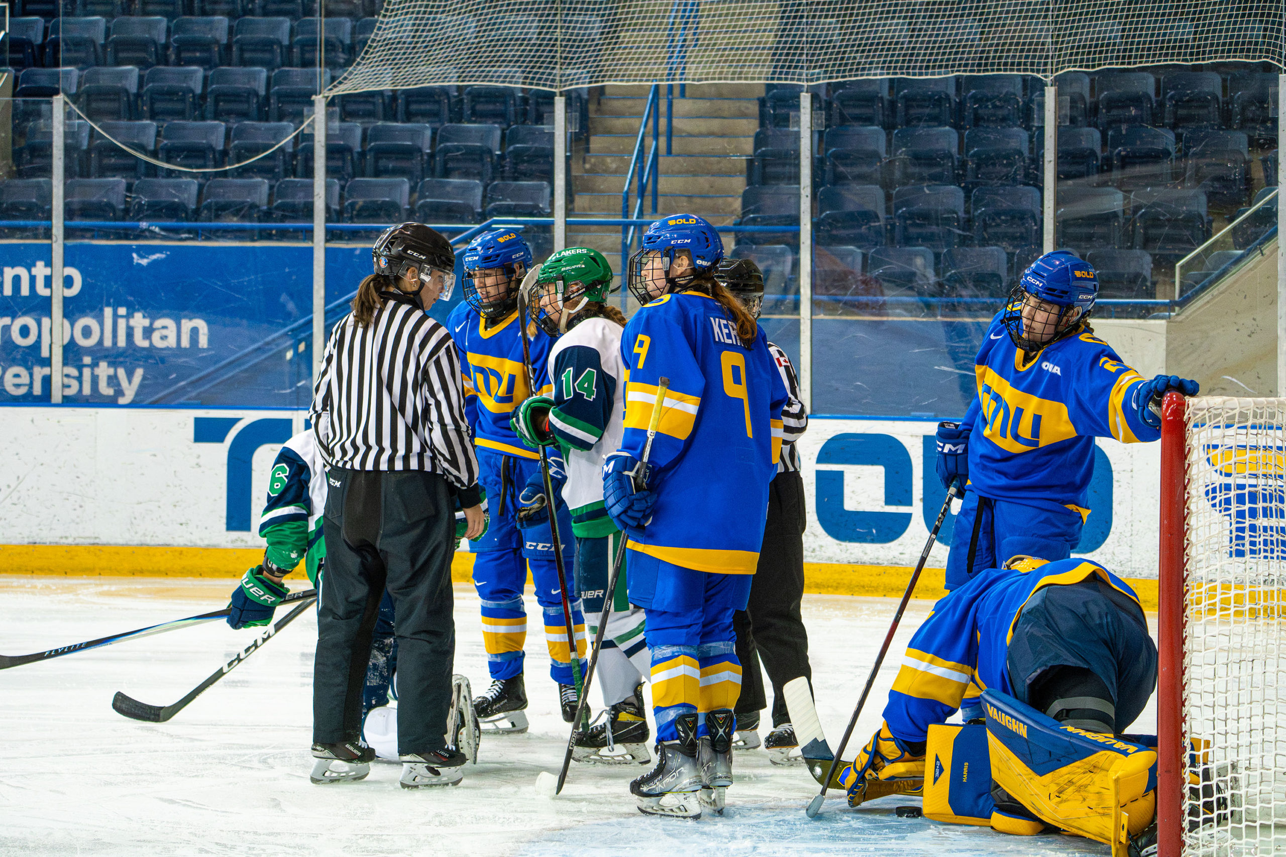 TMU and Nipissing players surround the TMU net