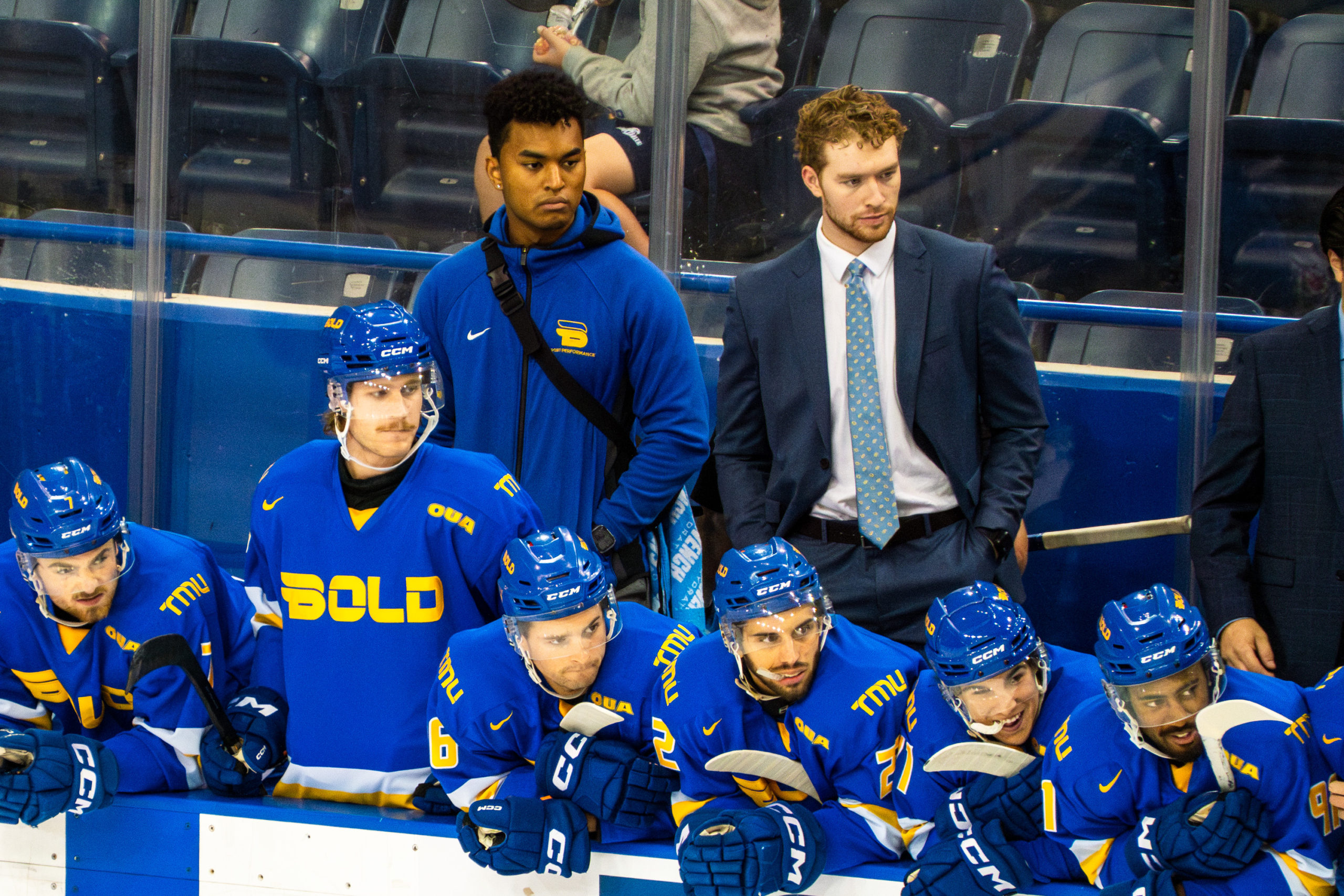 The TMU Bold men's hockey team watch the game from the bench