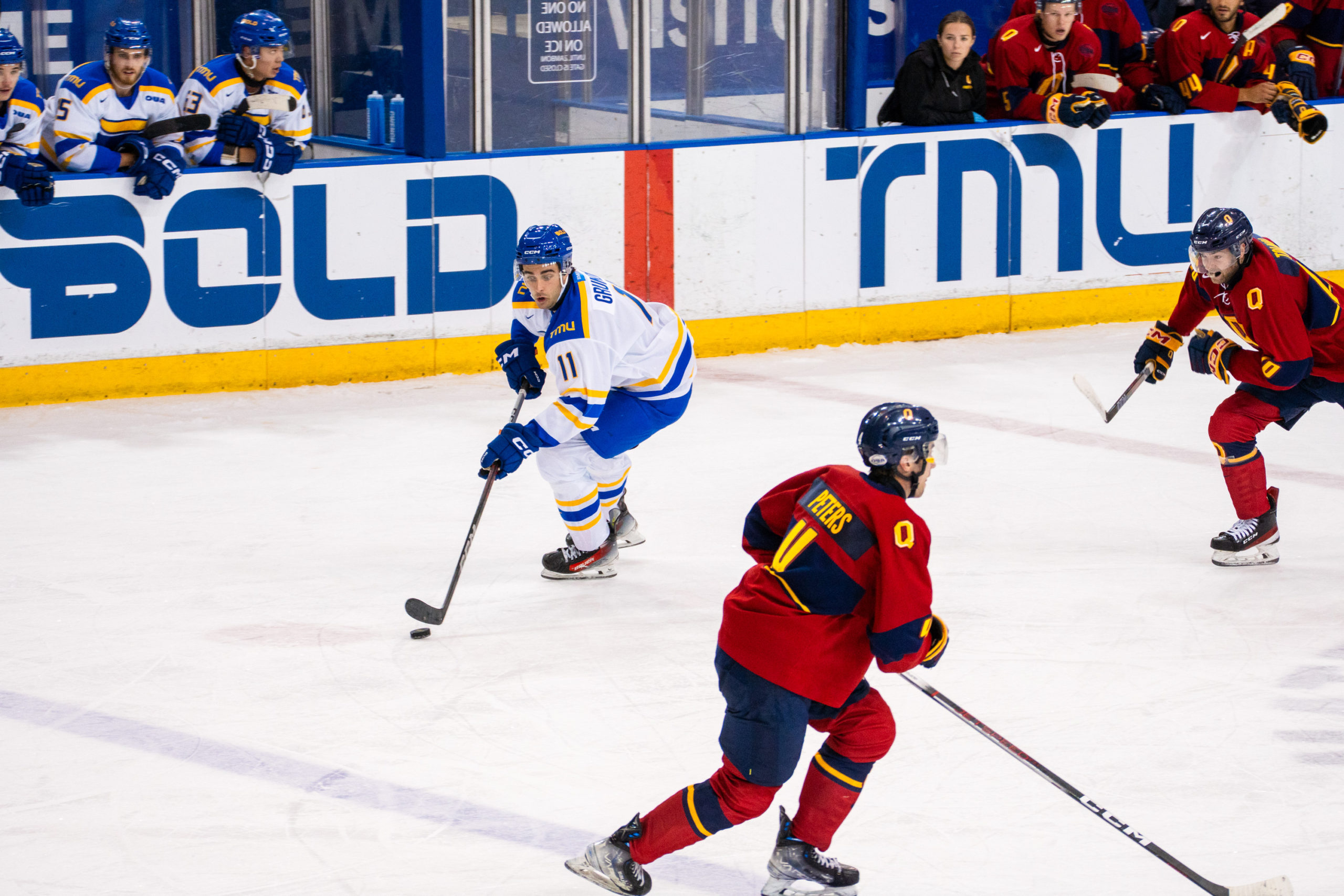 A TMU player holds onto the puck