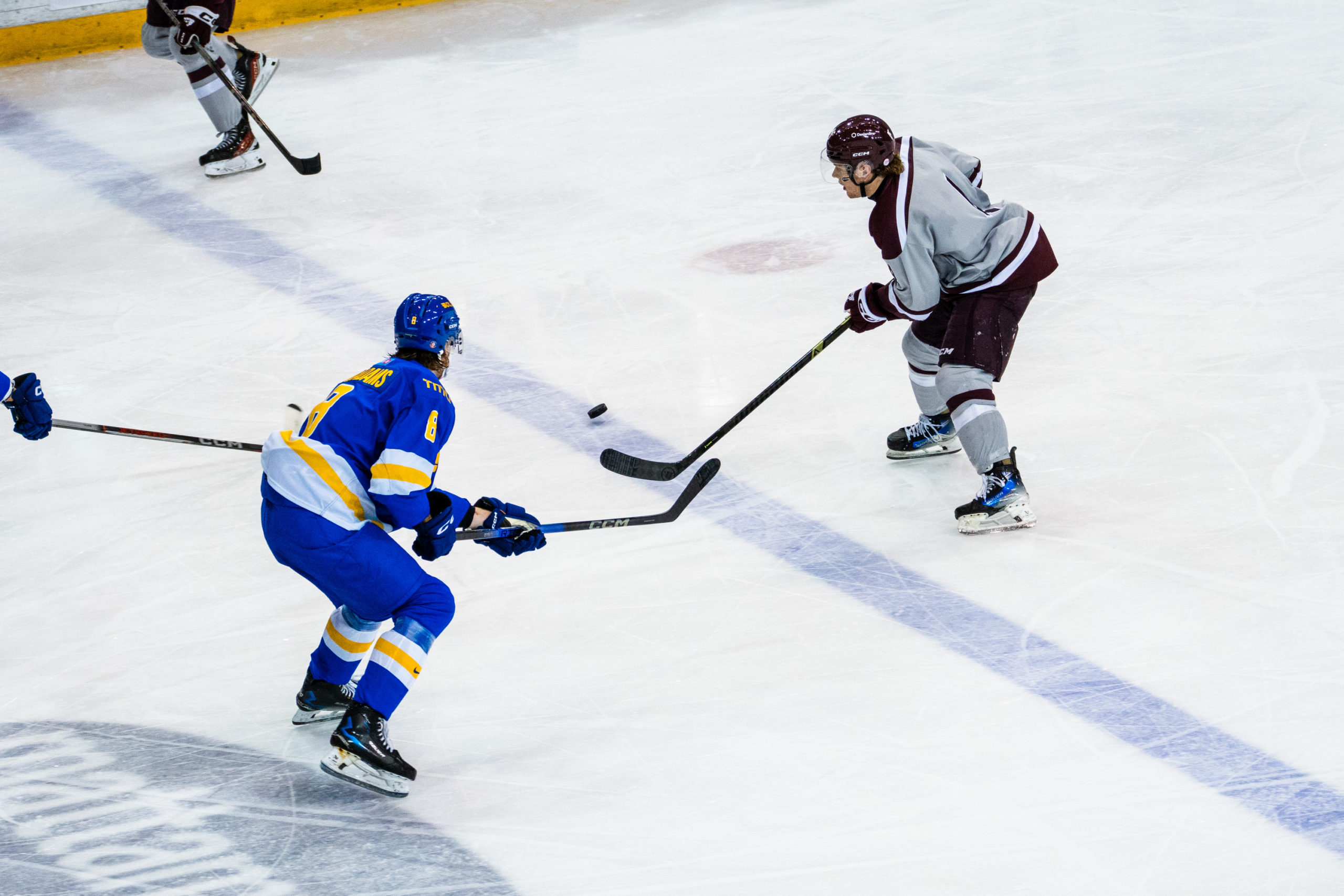 A TMU and Ottawa player reach the puck at the same time
