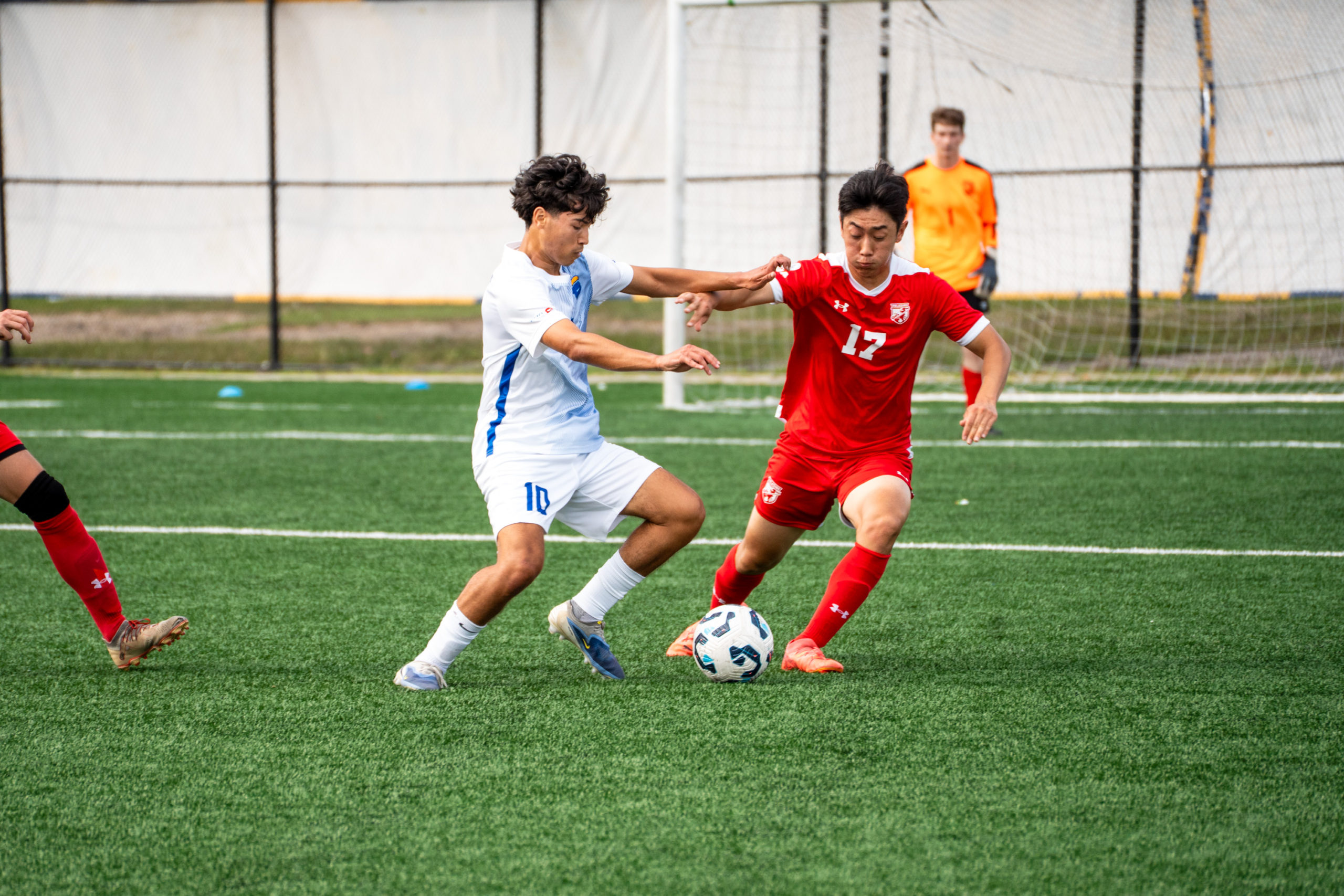 A TMU and RMC player race to gain possession of the ball