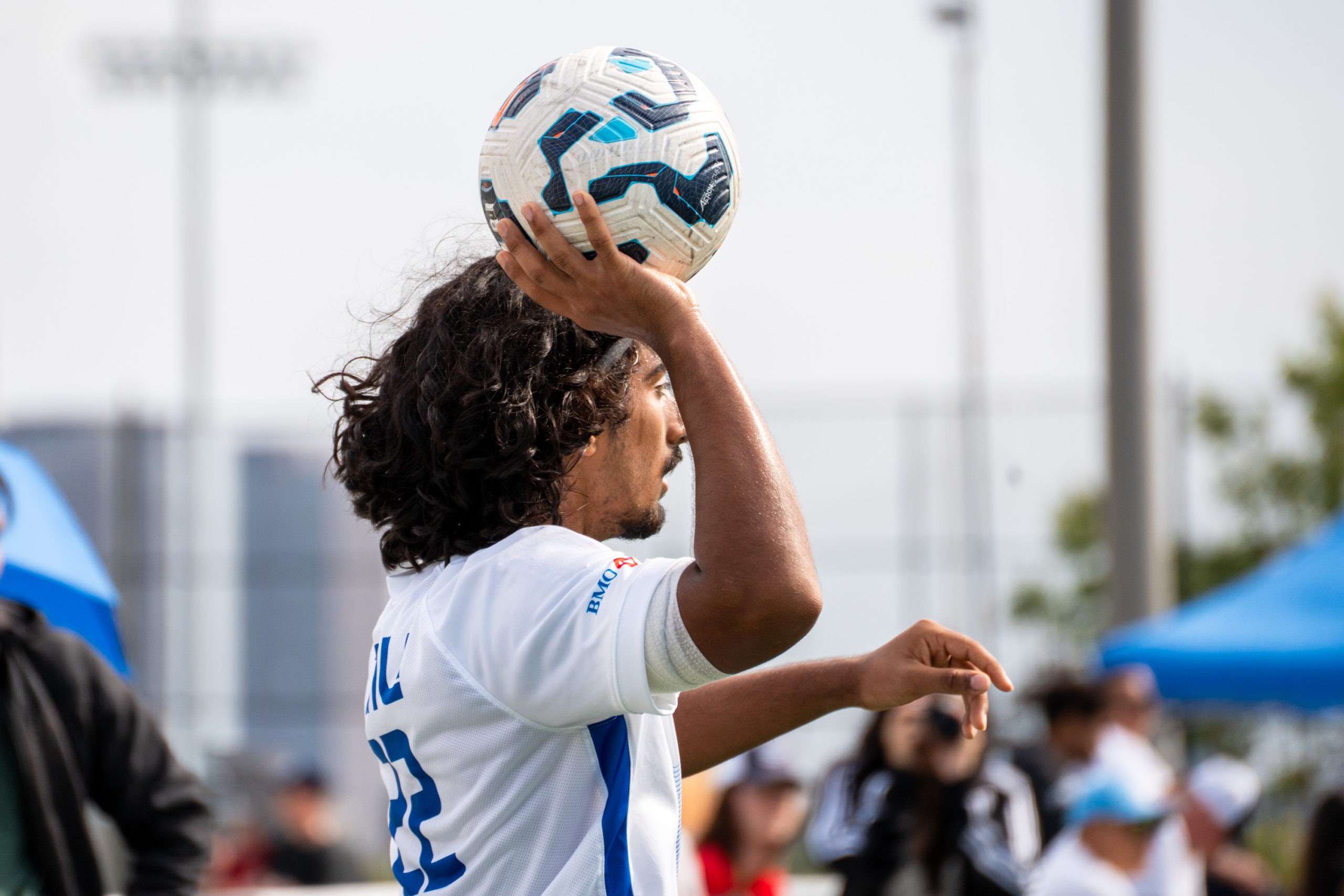 A TMU soccer player prepares to throw the ball back onto the field