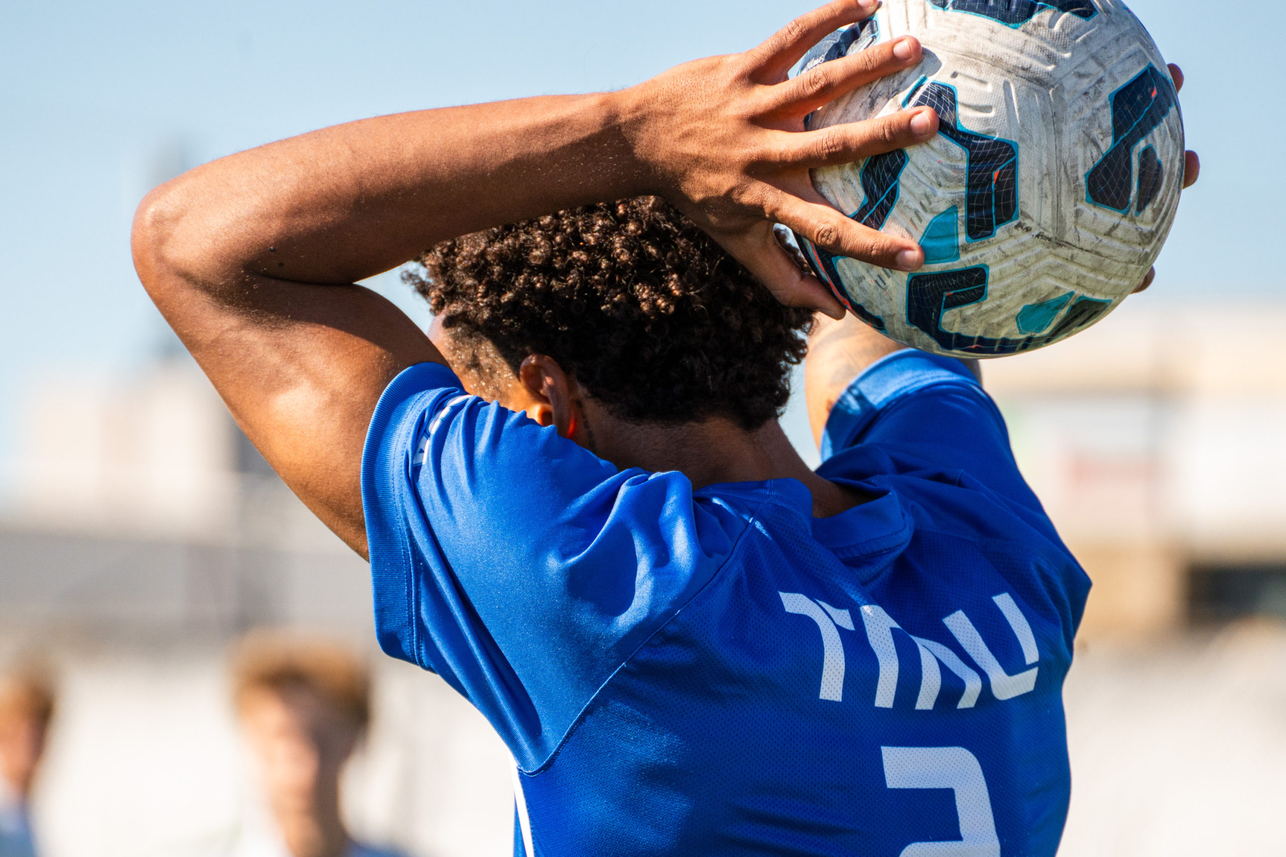 A TMU soccer player prepares to throw the ball back into the field