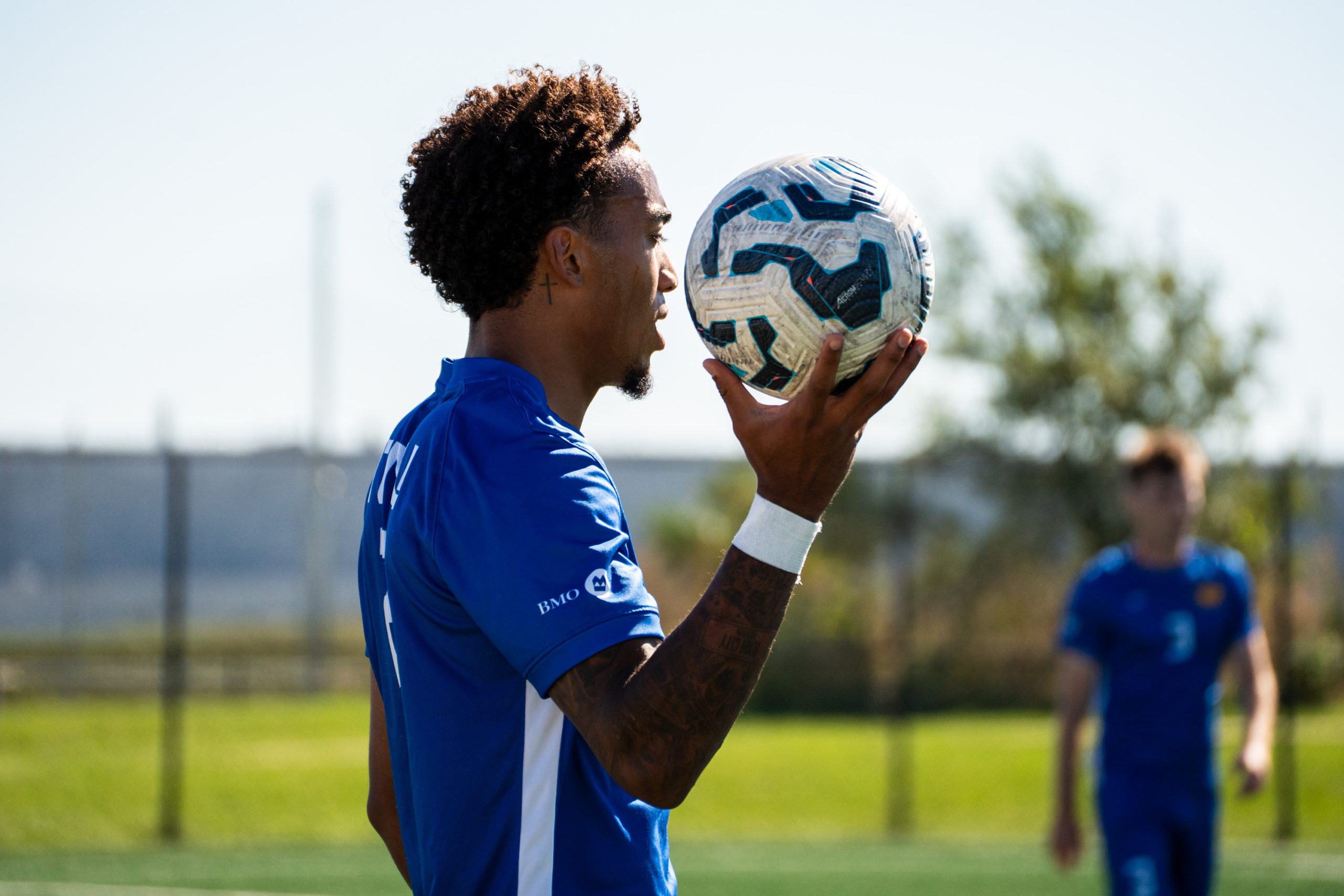 A TMU soccer player prepares to throw the ball back into the field
