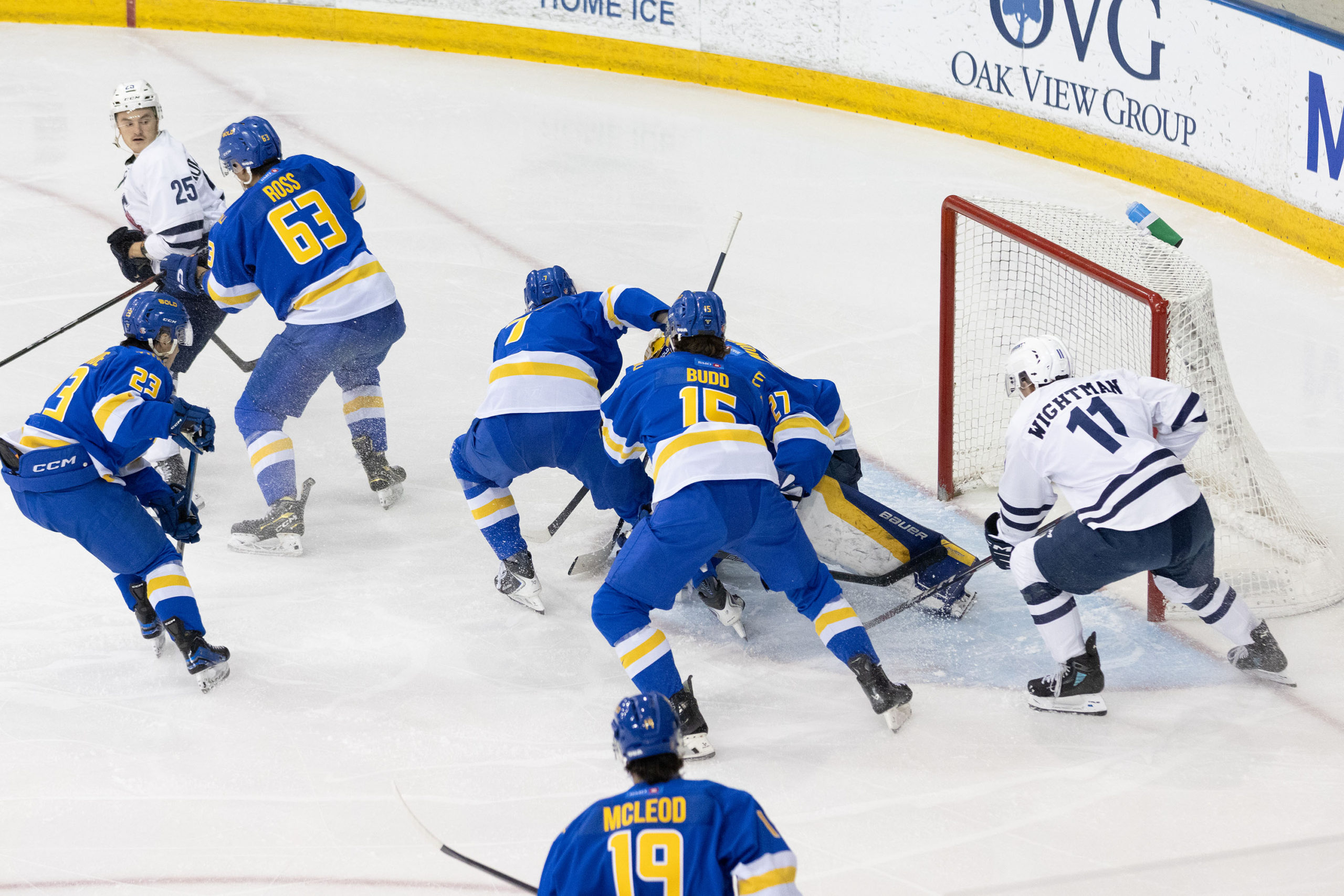 TMU and U of T players surround TMU's net