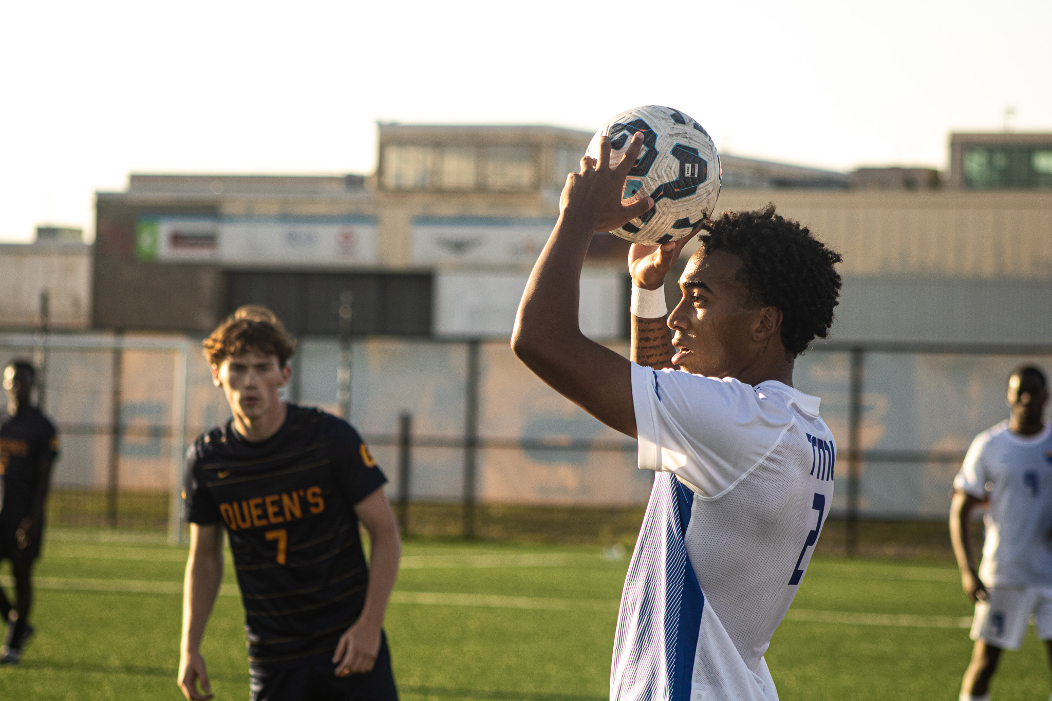 A soccer player prepares to throw the ball onto the field