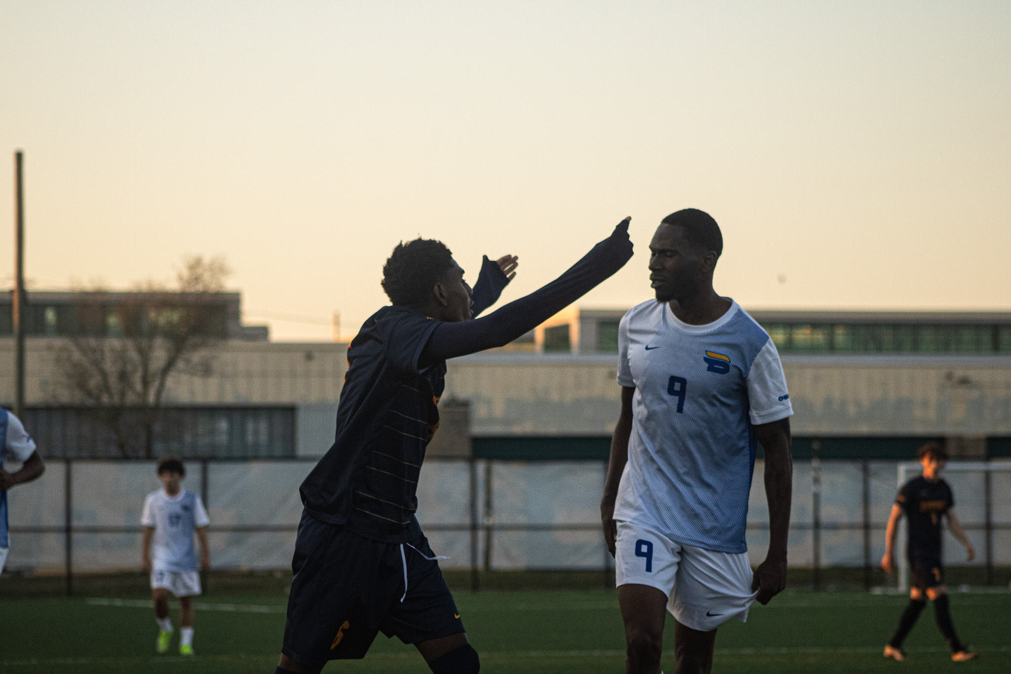 Two opposing soccer players argue with each other