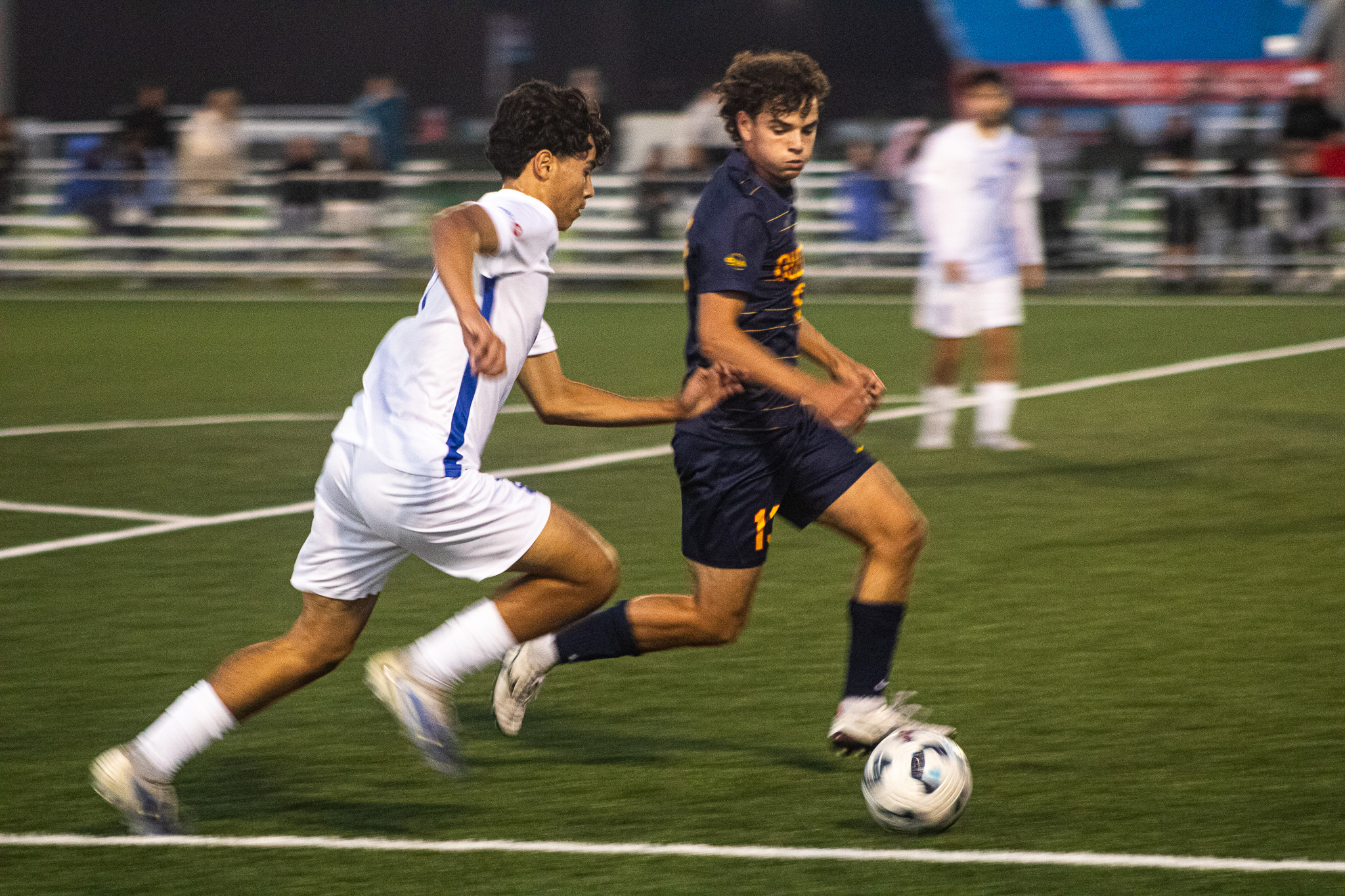 Two opposing soccer players race to the ball