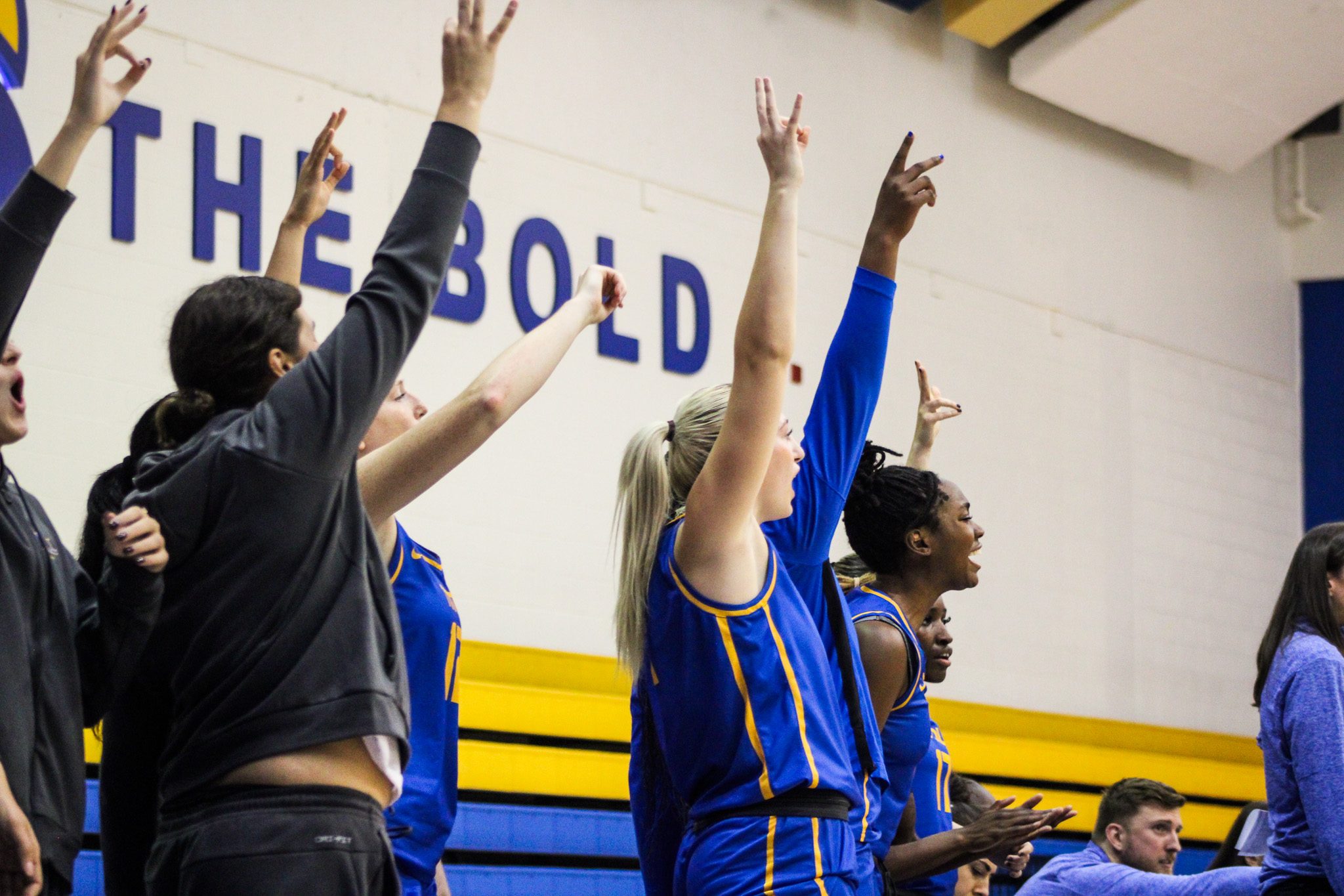 TMU players on the bench celebrate a basket
