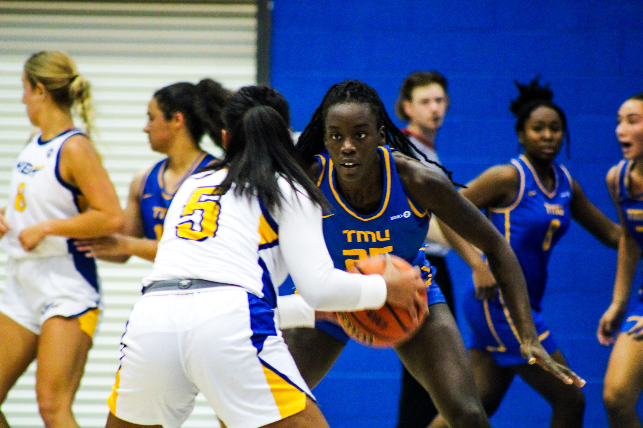 A TMU player blocks a UBC player with the ball