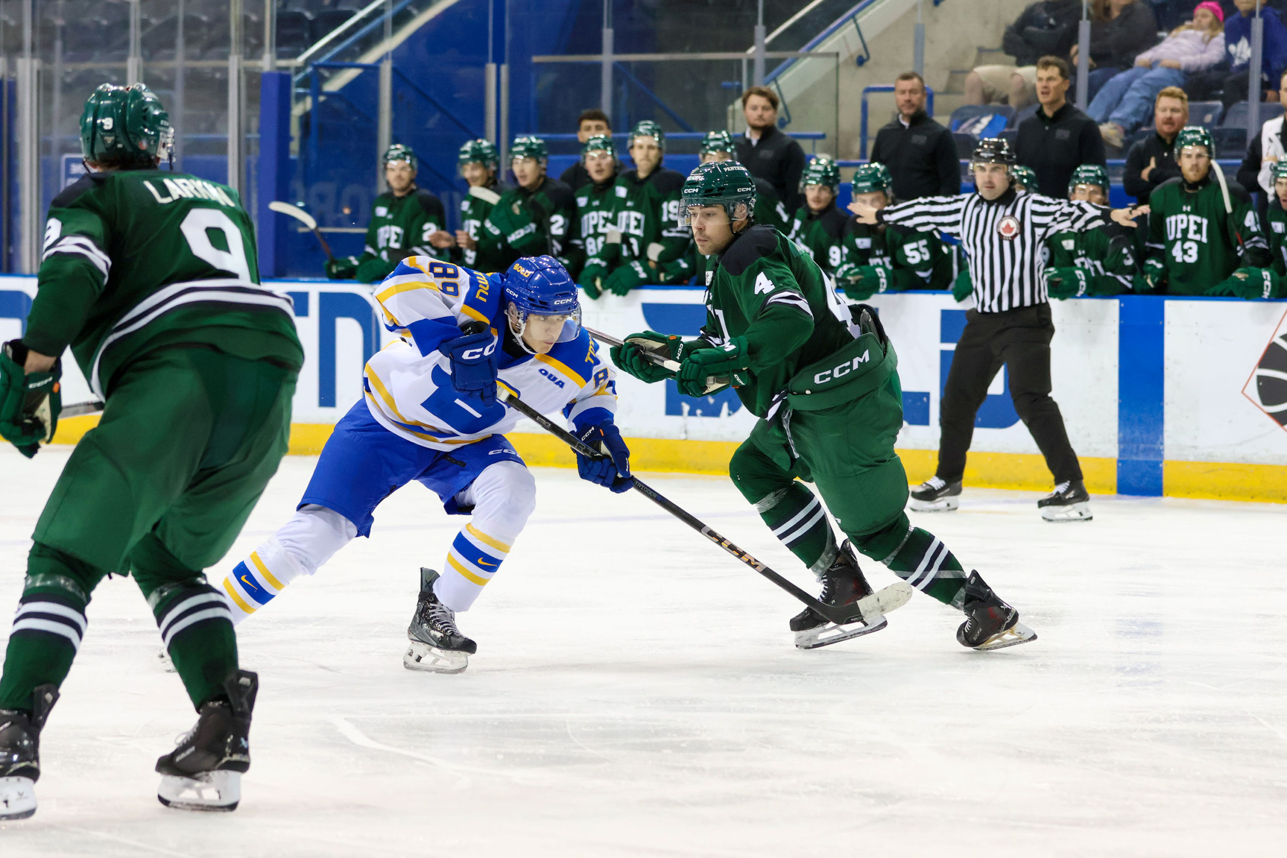 TMU and UPEI race to gain possession of the puck first
