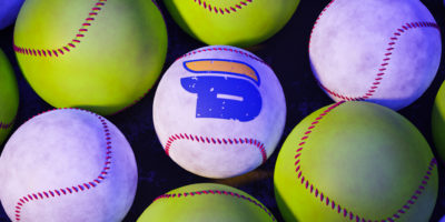 Illustration of yellow softballs, surrounding a row of three white baseballs, with the TMU Bold logo in the middle of one of the white baseballs.