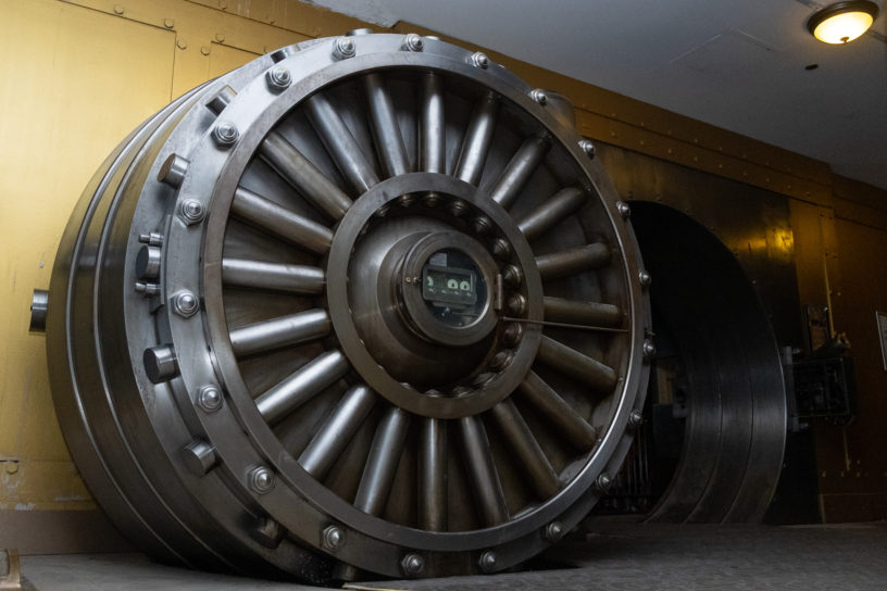 An image of a large bank vault door slightly ajar.