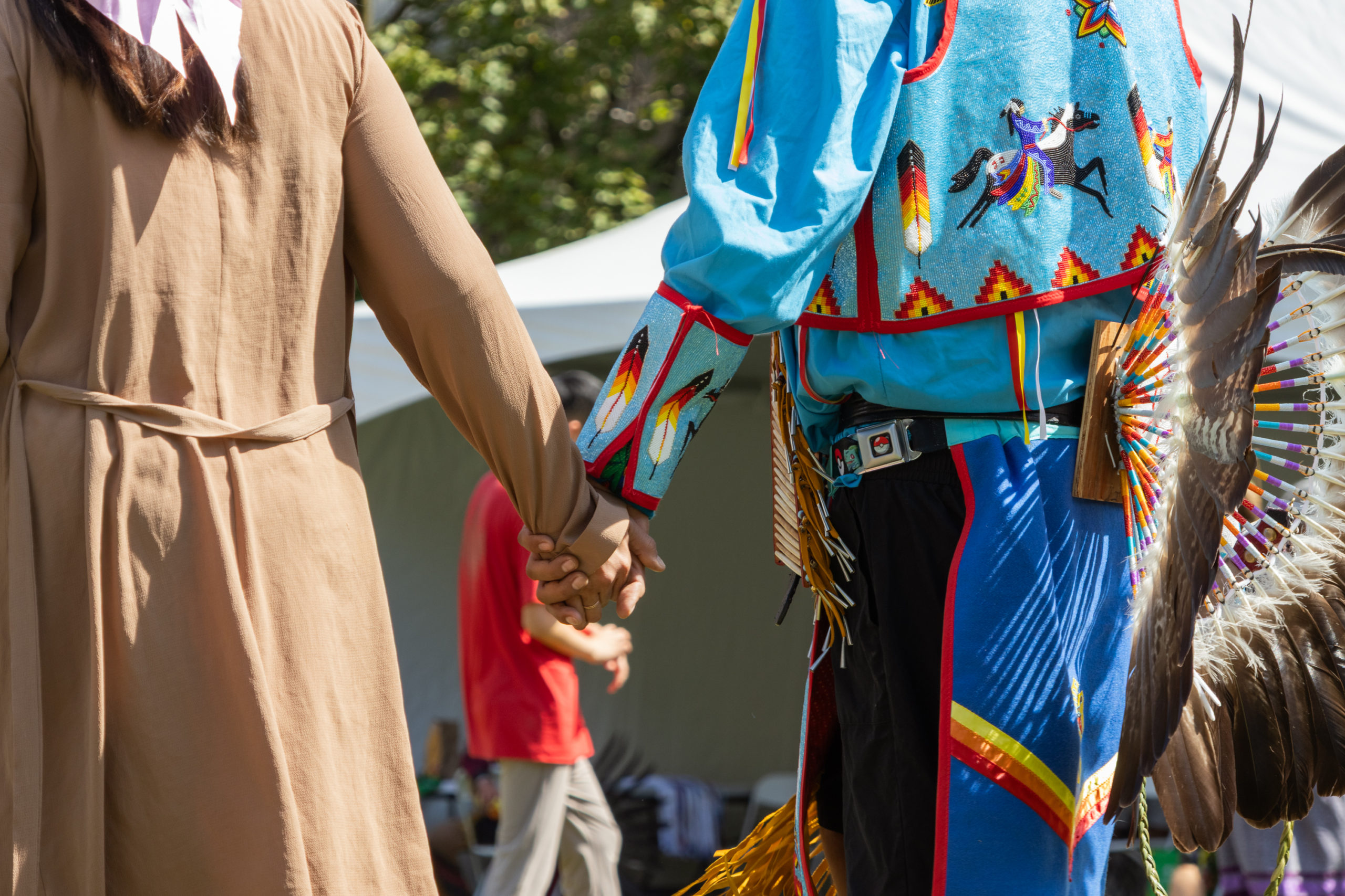 Close up of two people holding hands.