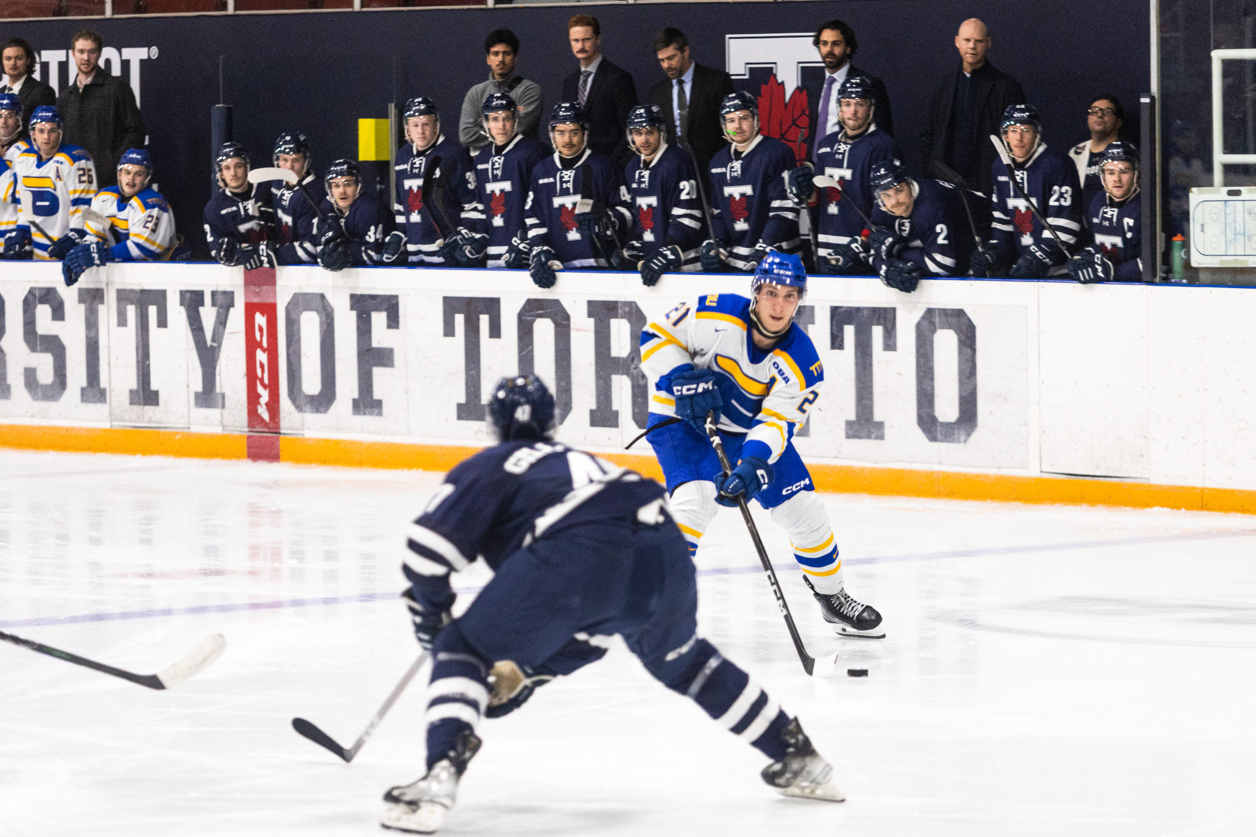 TMU player prepared to make a decision with the puck with a U of T defender in front