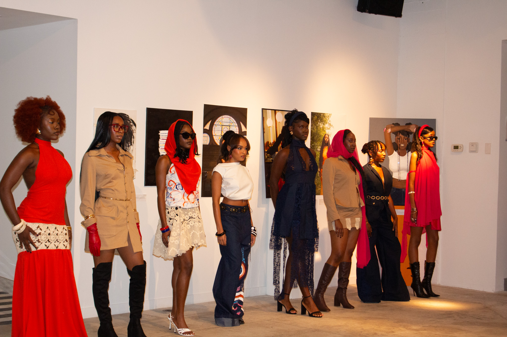 A group of people lined up side by side in front of illustrations on a wall.