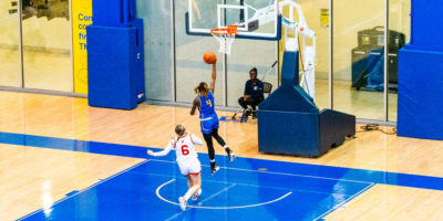 A TMU basketball player attempts a basket