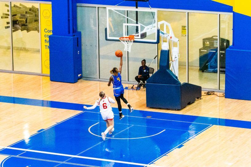 A TMU basketball player attempts a basket