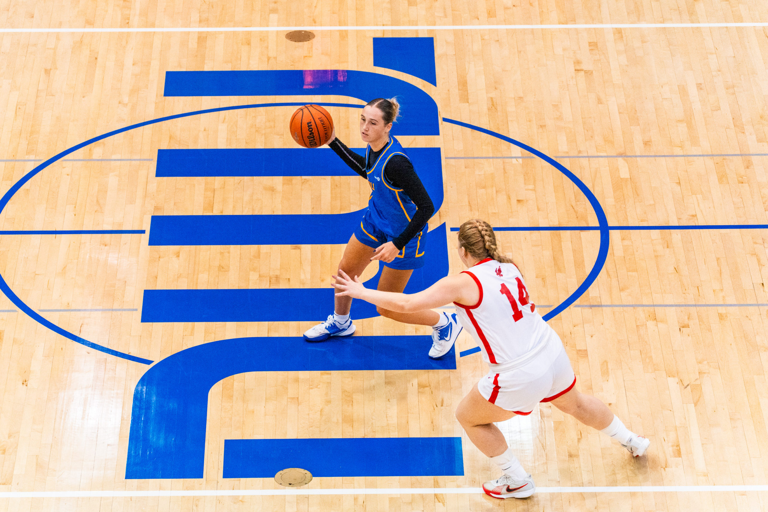A TMU and Memorial player battle on the court