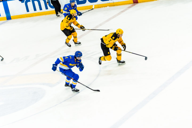 TMU and Waterloo players race across the ice