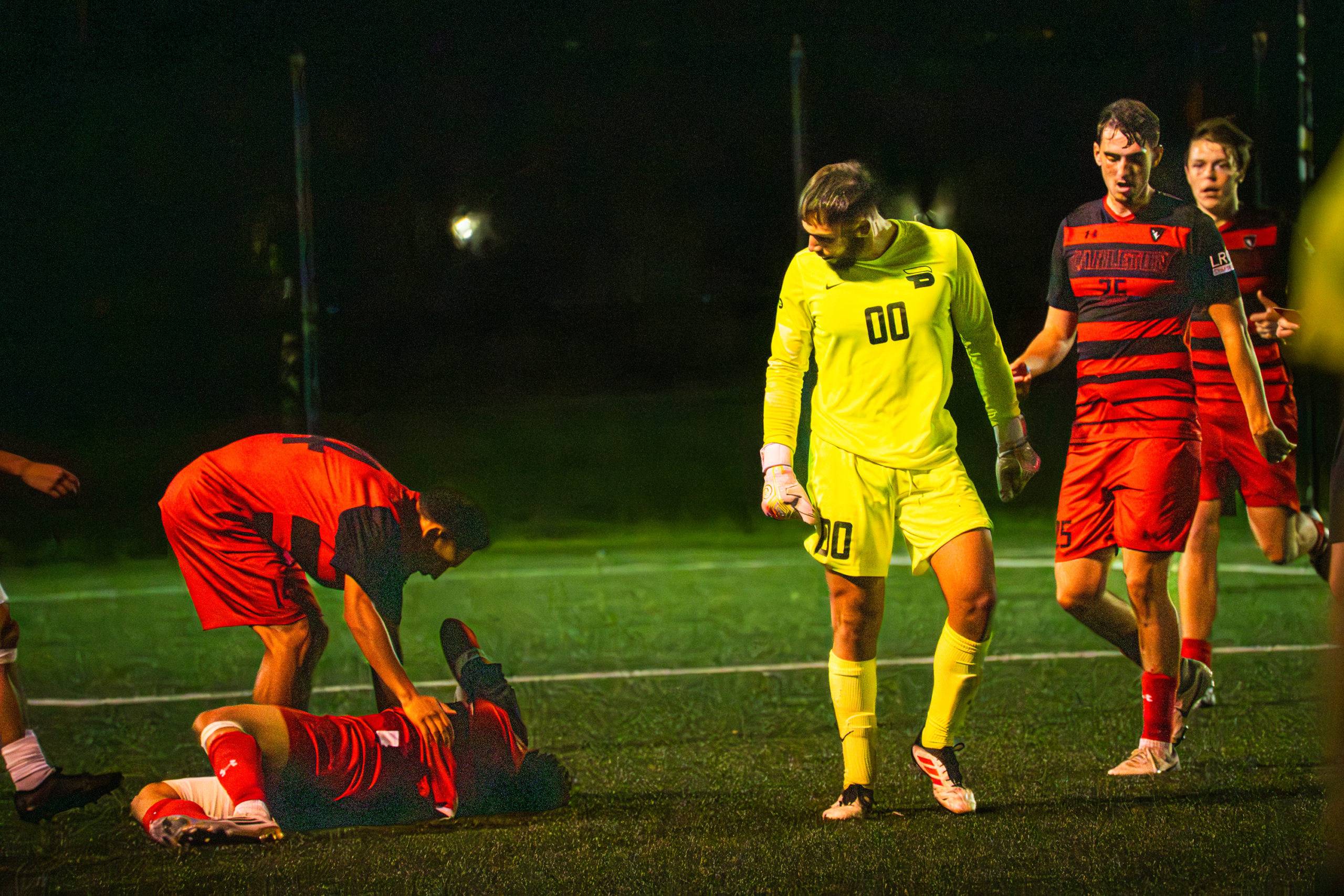 Carleton players surround an injured teammate