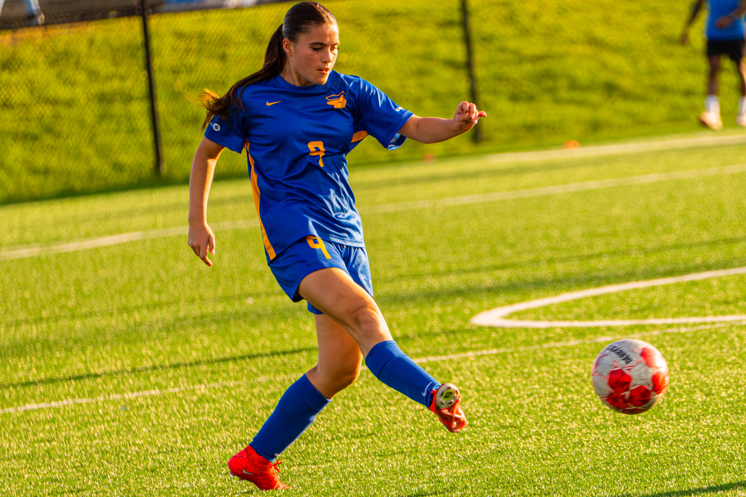 A TMU soccer player kicks the ball