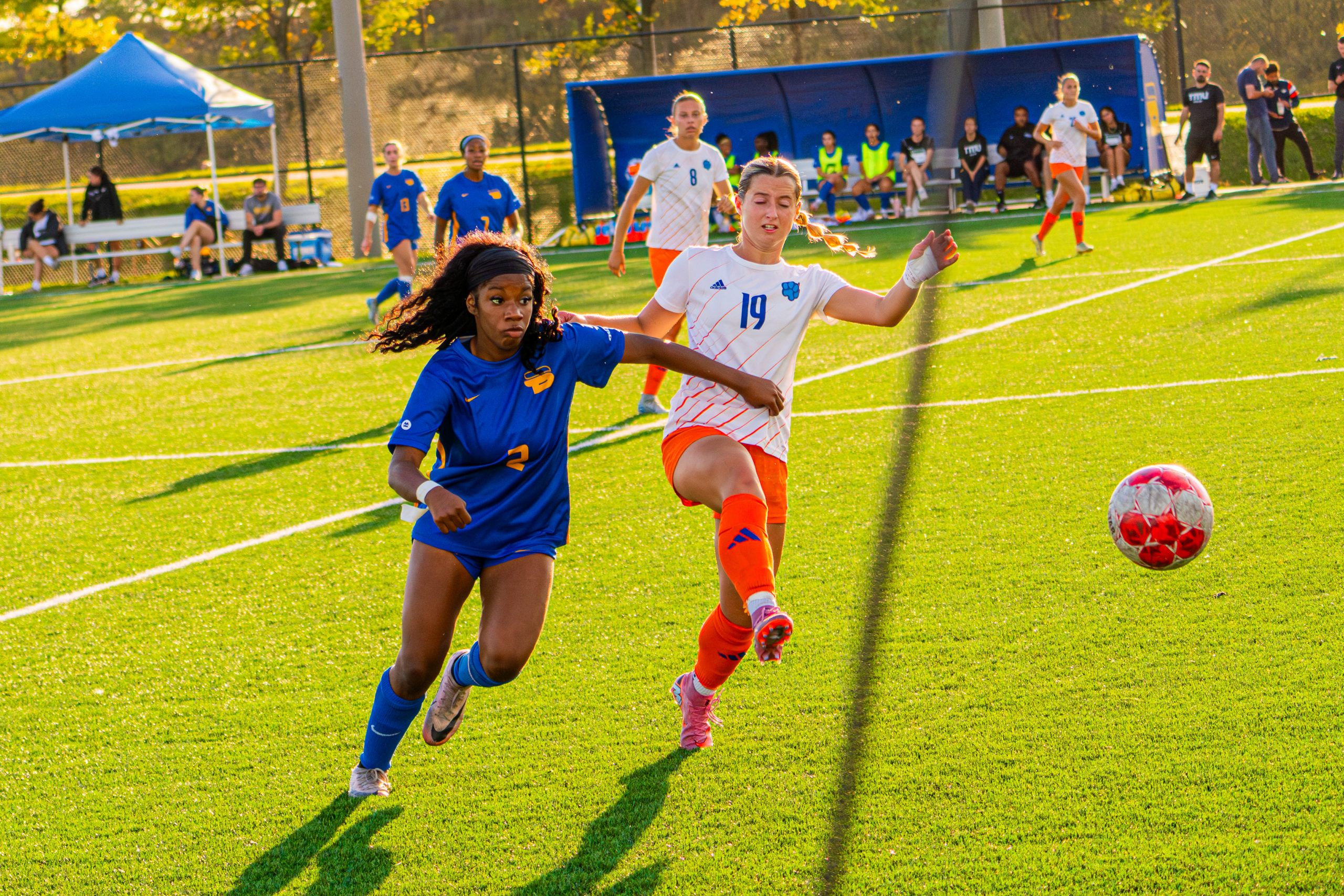 A TMU and Ontario Tech player fight for possession