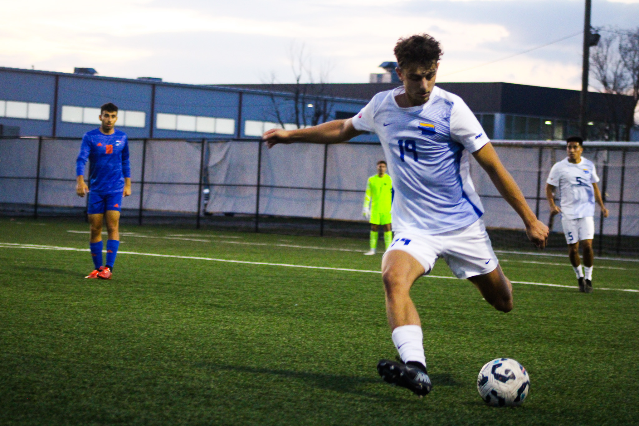 A TMU player kicks the ball