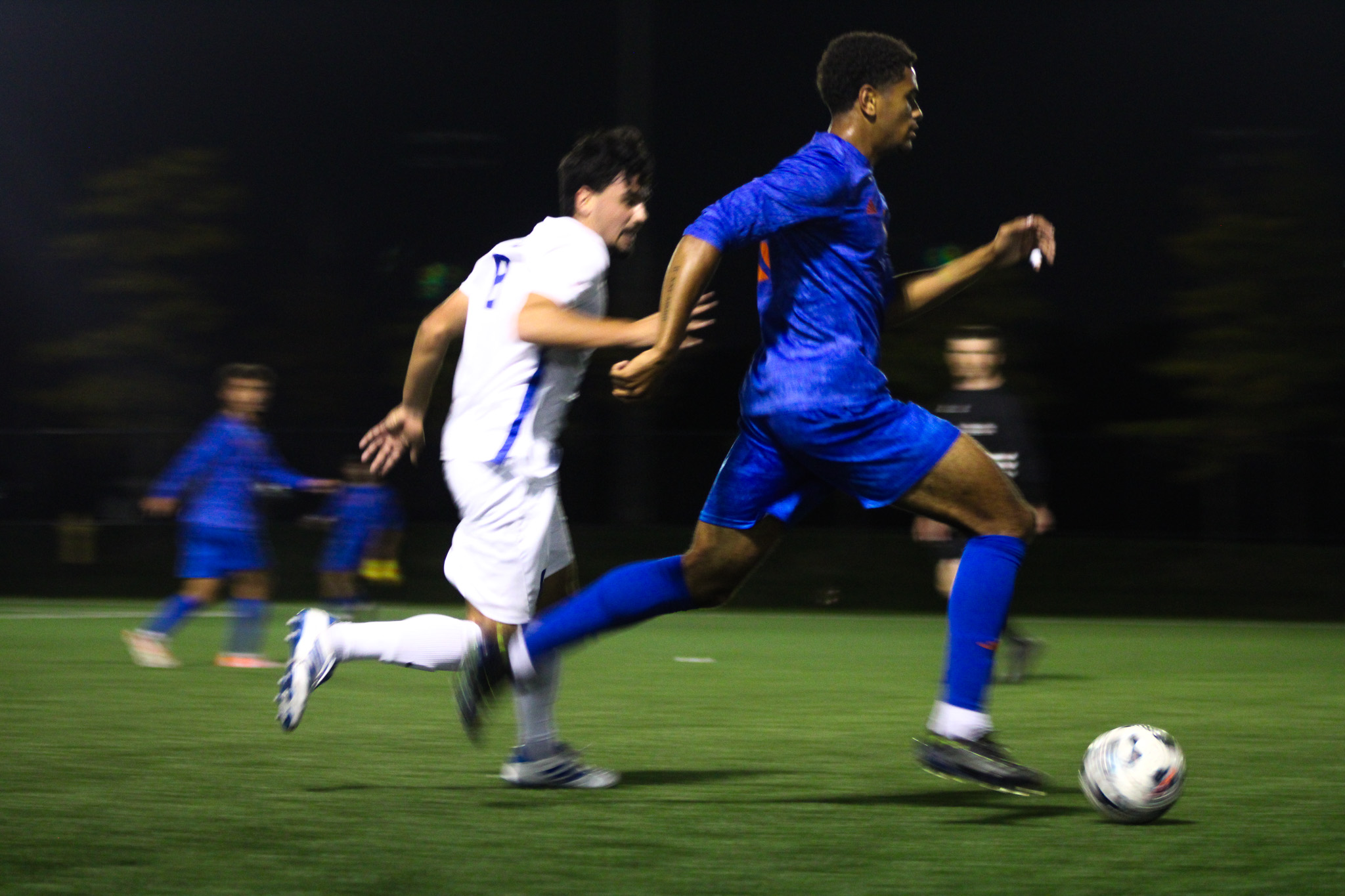 A TMU and Ontario Tech player race to gain possession