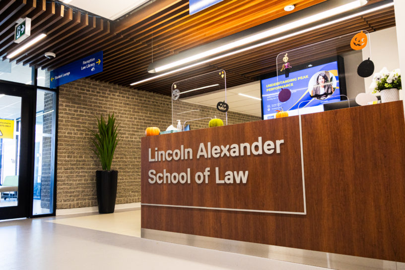 Image of a brown desk that reads "Lincoln Alexander School of Law".