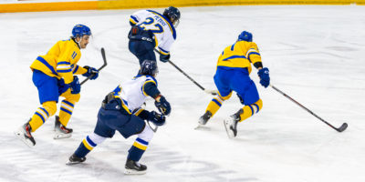TMU and Lakehead players scurry along the ice