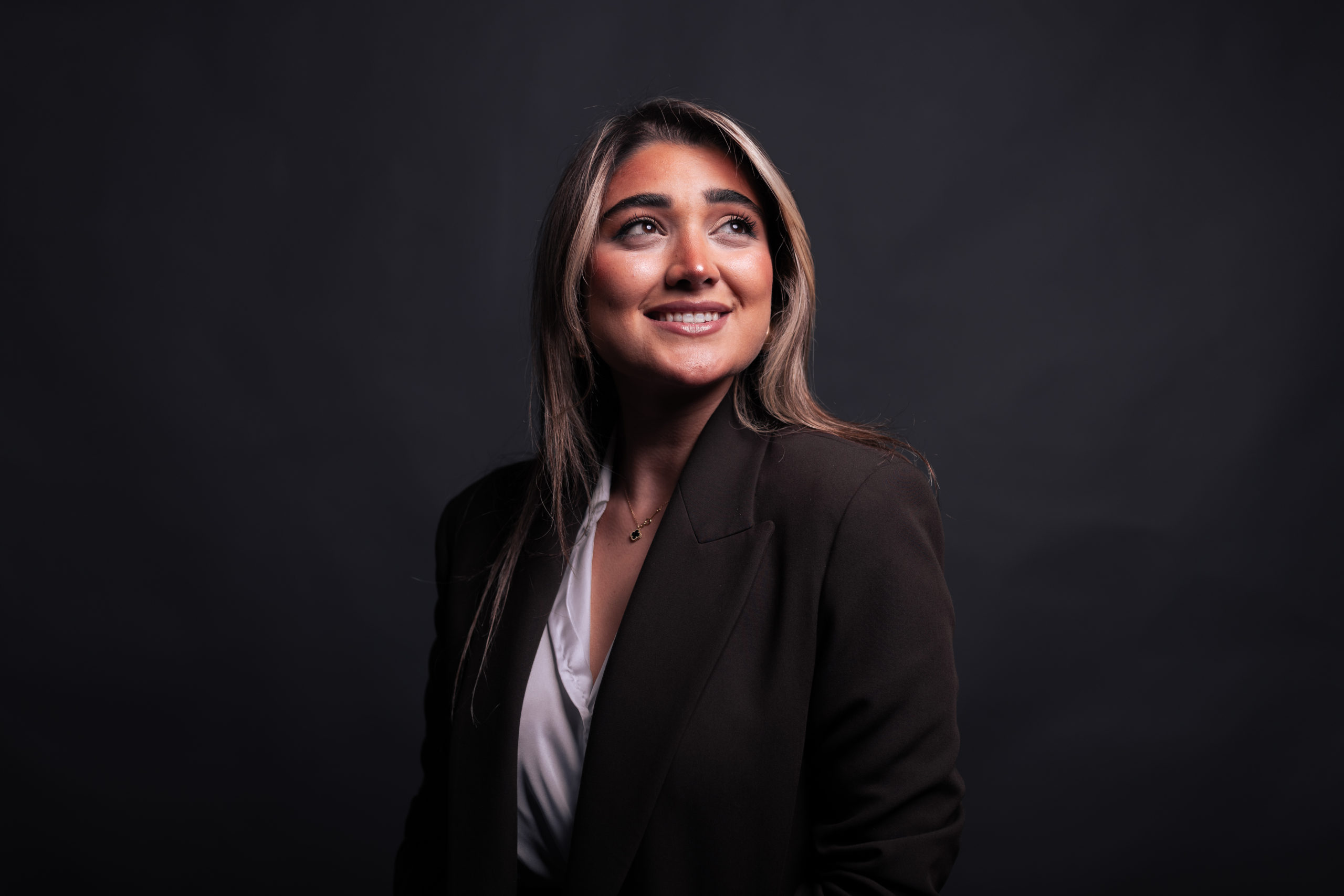 Woman looking upwards on a black background.