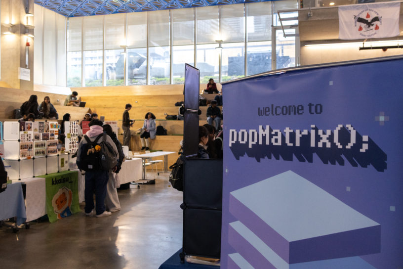 Image of the interior of the SLC lobby with booths set up and a sign that reads "welcome to popMatrix."