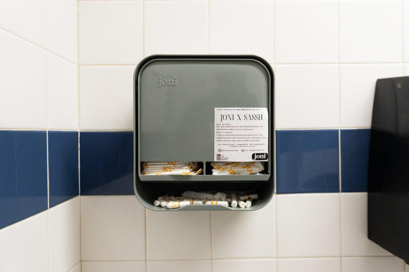 Image of a menstrual product dispenser that is mounted on a tile wall.