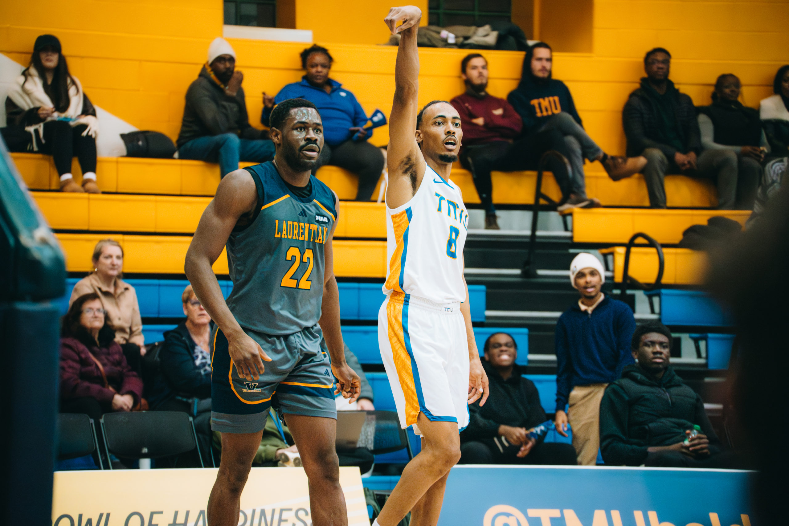 A Laurentian and TMU player stand side by side on the court