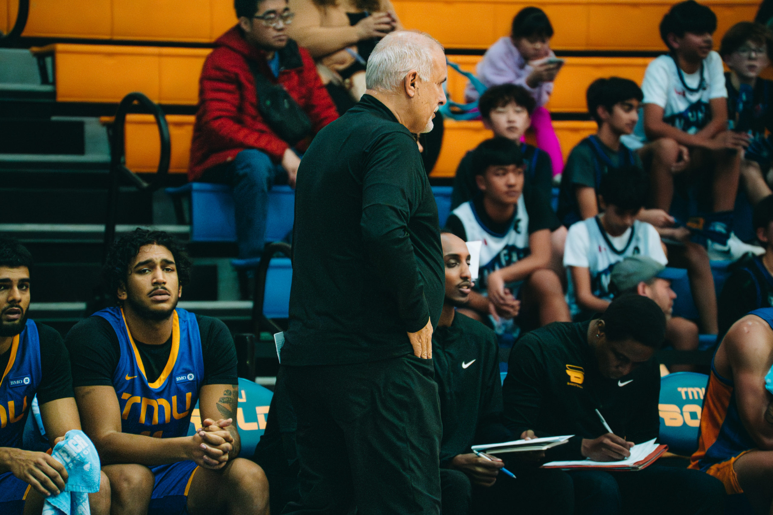 David DeaVeiro walking in front of the bench at the Mattamy Athletics Centre